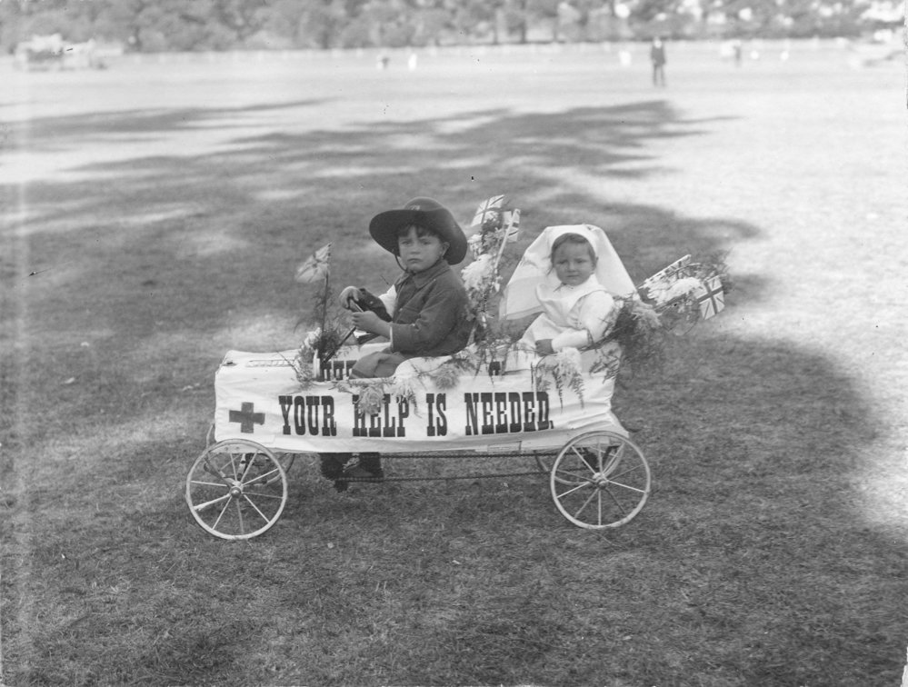 Two small children seated in a toy car