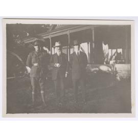 Three men outside a house